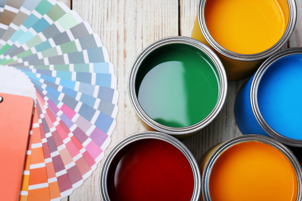 Interior Decorator - Cans with paint and color palette on wooden background, top view